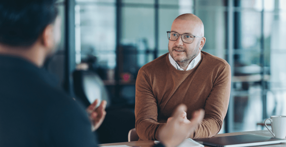 Business professionals in conversation, representing human-led customer experience and empathetic support.