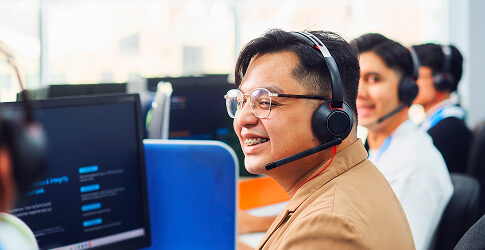 Smiling Probe CX agents wearing headsets at their desks