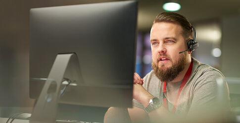 Customer service agent wearing a headset at his desk