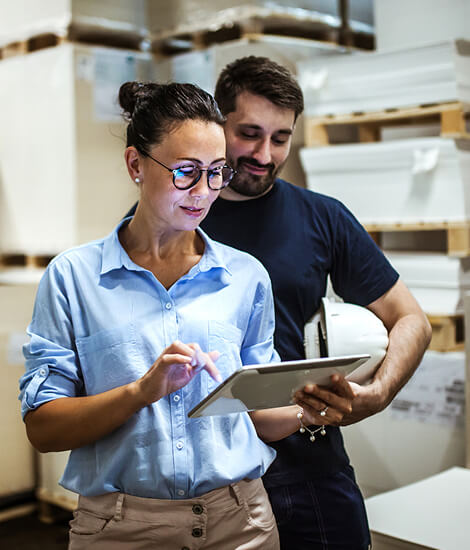Warehouse supervisor talking with a manager holding a tablet