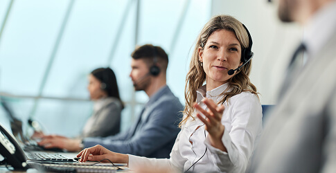 Customer service representative talking with colleagues in a call centre