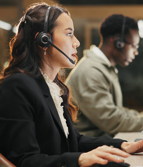 Call centre agent with a headset at her computer