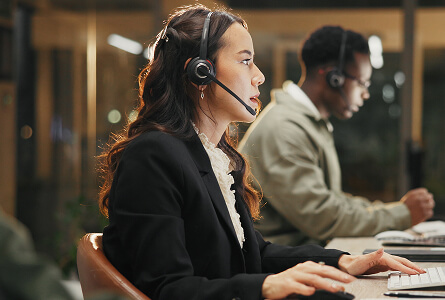 Call centre agent with a headset at her computer