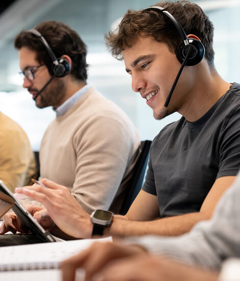 Smiling customer service team working at their desks