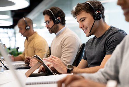 Smiling customer service team working at their desks