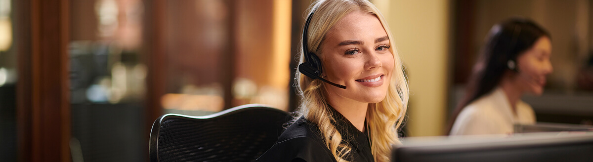 Smiling customer service trainee wearing a headset