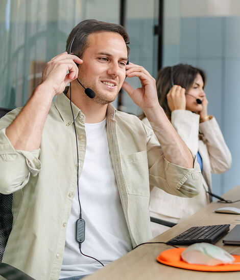 Smiling agent adjusting his headset at his desk