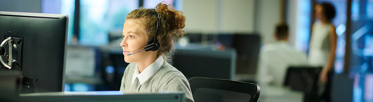 Call centre agent wearing a headset at her desk