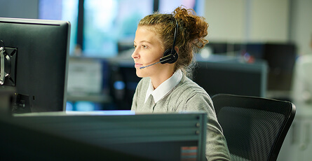 Call centre agent wearing a headset at her desk