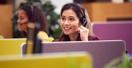 Smiling helpdesk agent talking on a headset