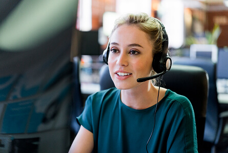 Customer service agent wearing a headset at her desk