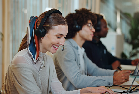 Smiling call centre consultant with colleagues