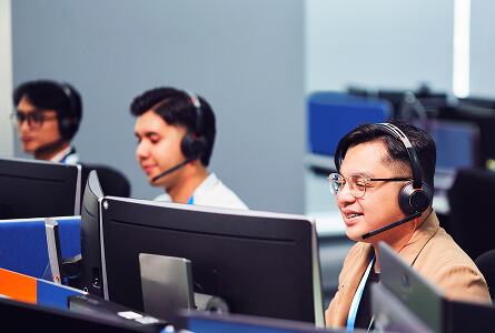 Customer service agents wearing headsets at their desks